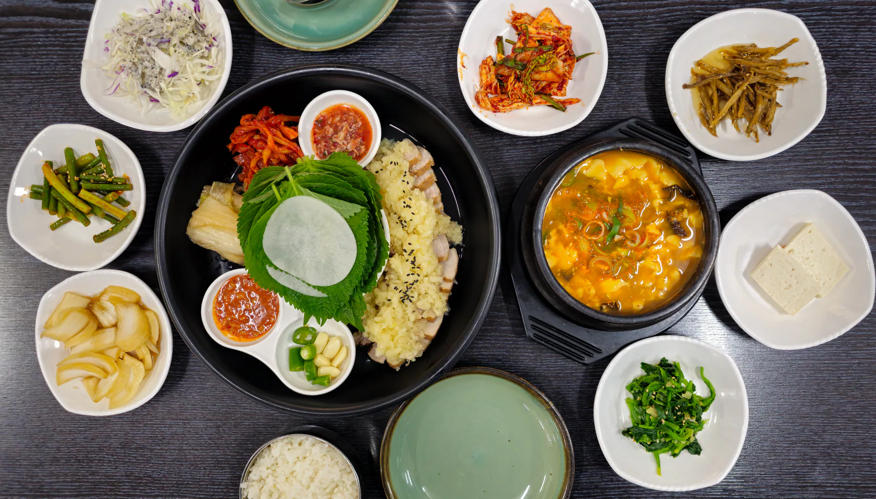 수육과 찌개, 김치와 나물 반찬으로 차린 한식